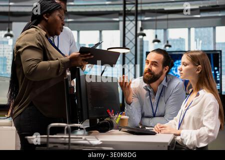 Team of software developers in office using AI automation scripts to reduce repetitive coding tasks. Coworkers doing brainstorming, using artificial intelligence technology in startup workspace Stock Photo