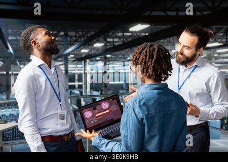 Diverse staff members worrying about malicious hacking cyber attack, dangerous data breach with critical error on server systems. Emergency protocol to protect hardware infrastructure. Stock Photo