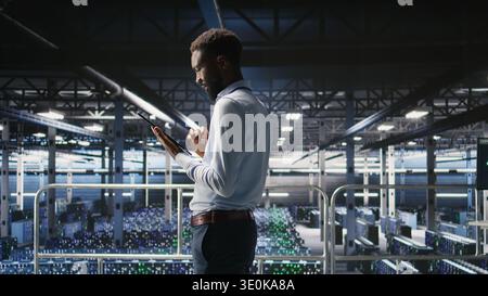 Data center engineer doing maintenance tasks on systems to ensure optimal performance. IT professional reviewing diagnostics and applying patches to server hub improve stability, Stock Photo