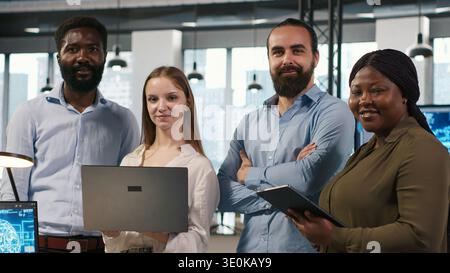 Portrait of happy teamworking engineers writing code, developing machine learning APIs. Team of smiling IT experts troubleshooting software errors using artificial intelligence, camera A Stock Photo