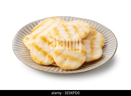Japanese salad rice crackers (Salad Senbei) on a ceramic plate isolated on white background Stock Photo