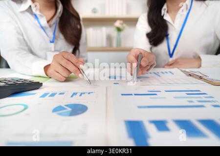 Data Collaboration. Professionals analyzing financial charts and graphs in a modern office. Stock Photo