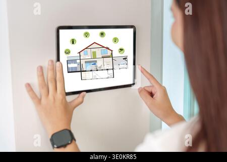 Smart Home Management. Woman using tablet to control home features. Stock Photo