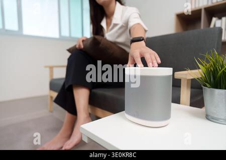 Smart Speaker Control. User adjusting smart speaker settings at home. Stock Photo