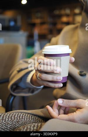 Warm drink held by a person in a cafe Stock Photo
