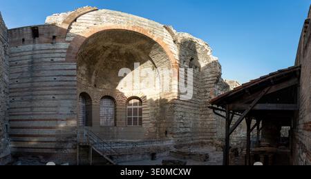 Panoramic view inside the Thermes de Constantin in Arles, France, featuring a massive barrel vault, brick arch, stone walls, and restored windows in t Stock Photo