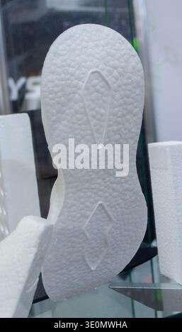 White sole of sports shoes. Products made from foamed polymers expanded polypropylene EPP and expanded polystyrene EPS. Model of dense and lightweight material, universal foam. New modern technologies Stock Photo