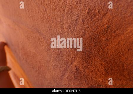 Sandstone rock surface texture with natural erosion patterns on weathered stone wall close up Stock Photo