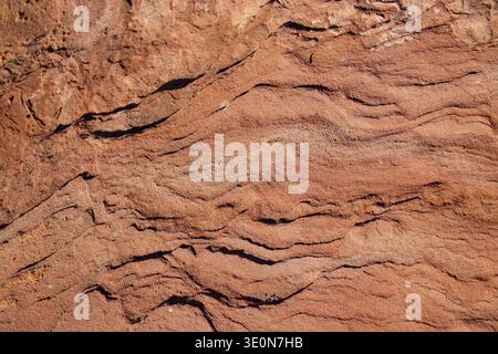 Close-up of layered red sandstone surface showing natural sedimentary rock texture and erosion patterns Stock Photo