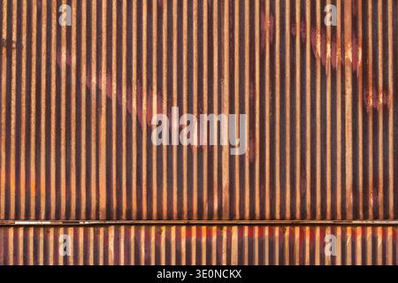 Rusty corrugated metal sheet texture background. Old weathered orange and brown iron surface with vertical lines.  Close-up of aged and corroded corru Stock Photo