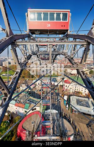 A view shows the metal structure of the Giant Ferris Wheel in Vienna with the Prater amusement park visible below on a clear day. Stock Photo