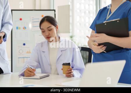 Healthcare professionals collaborating in a meeting, discussing patient care strategies Stock Photo