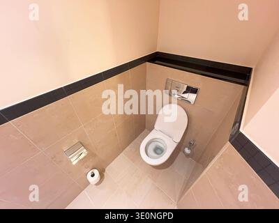 Contemporary tiled bathroom featuring a closed-lid toilet Stock Photo