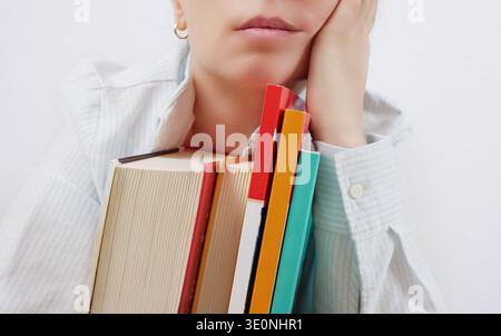 Tired student holding books in hands Stock Photo