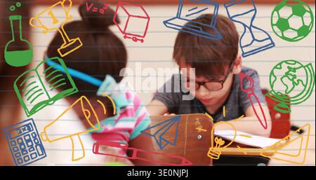 Writing boy with dark-framed glasses leaning over notebook at school desk, with colorful doodles Stock Photo