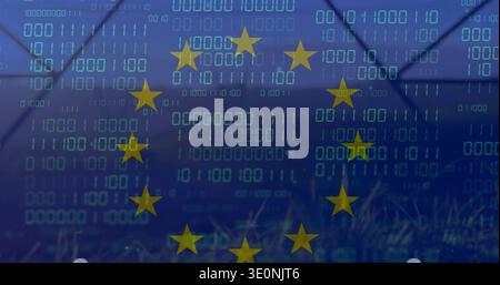 Displaying circle of 12 yellow stars over cyan binary digits on blue field, fence silhouette, grass Stock Photo