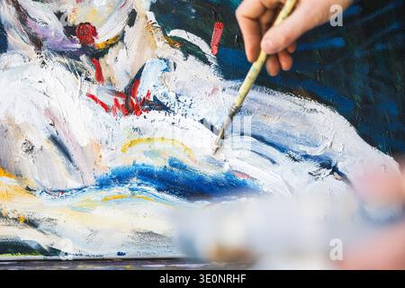 Close-up of female artist's hand painting with oil paints Stock Photo