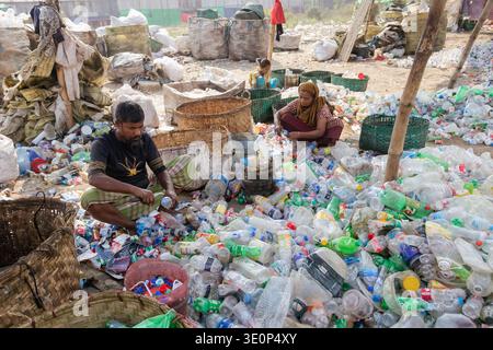 March 13, 2026, Dhaka, Dhaka, Bangladesh: A woman worker sorts used plastic bottles in a recycling factory in Dhaka, Bangladesh. She helps to prevent the bottles from being discarded, sent to landfill, where they can take 1,000 years to biodegrade, or incinerated, which produces toxic fumes. The emission of CO2 and other greenhouse gases will be reduced if recycling takes place in the production of new plastics. This small yet significant act supports environmental sustainability by promoting a responsible cycle of reuse, reducing the strain on natural resources, and safeguarding our ecosystem Stock Photo