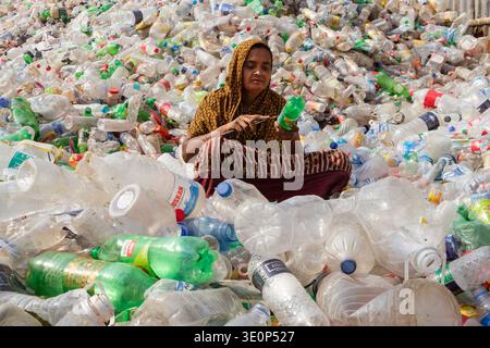 March 13, 2026, Dhaka, Dhaka, Bangladesh: A woman worker sorts used plastic bottles in a recycling factory in Dhaka, Bangladesh. She helps to prevent the bottles from being discarded, sent to landfill, where they can take 1,000 years to biodegrade, or incinerated, which produces toxic fumes. The emission of CO2 and other greenhouse gases will be reduced if recycling takes place in the production of new plastics. This small yet significant act supports environmental sustainability by promoting a responsible cycle of reuse, reducing the strain on natural resources, and safeguarding our ecosystem Stock Photo