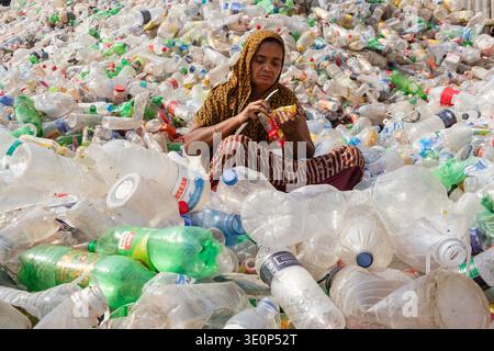 March 13, 2026, Dhaka, Dhaka, Bangladesh: A woman worker sorts used plastic bottles in a recycling factory in Dhaka, Bangladesh. She helps to prevent the bottles from being discarded, sent to landfill, where they can take 1,000 years to biodegrade, or incinerated, which produces toxic fumes. The emission of CO2 and other greenhouse gases will be reduced if recycling takes place in the production of new plastics. This small yet significant act supports environmental sustainability by promoting a responsible cycle of reuse, reducing the strain on natural resources, and safeguarding our ecosystem Stock Photo