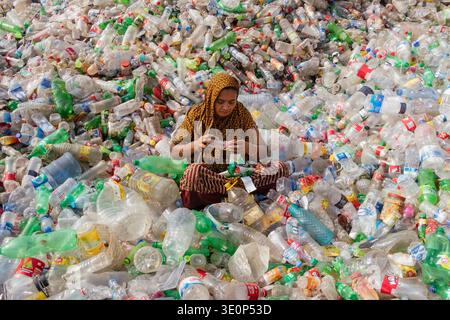 March 13, 2026, Dhaka, Dhaka, Bangladesh: A woman worker sorts used plastic bottles in a recycling factory in Dhaka, Bangladesh. She helps to prevent the bottles from being discarded, sent to landfill, where they can take 1,000 years to biodegrade, or incinerated, which produces toxic fumes. The emission of CO2 and other greenhouse gases will be reduced if recycling takes place in the production of new plastics. This small yet significant act supports environmental sustainability by promoting a responsible cycle of reuse, reducing the strain on natural resources, and safeguarding our ecosystem Stock Photo