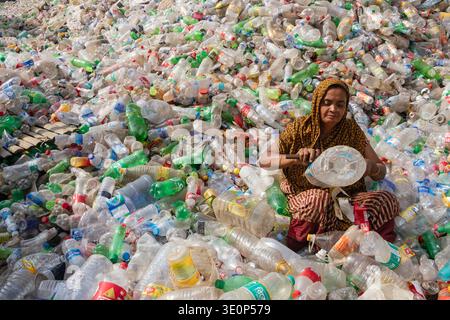 March 13, 2026, Dhaka, Dhaka, Bangladesh: A woman worker sorts used plastic bottles in a recycling factory in Dhaka, Bangladesh. She helps to prevent the bottles from being discarded, sent to landfill, where they can take 1,000 years to biodegrade, or incinerated, which produces toxic fumes. The emission of CO2 and other greenhouse gases will be reduced if recycling takes place in the production of new plastics. This small yet significant act supports environmental sustainability by promoting a responsible cycle of reuse, reducing the strain on natural resources, and safeguarding our ecosystem Stock Photo