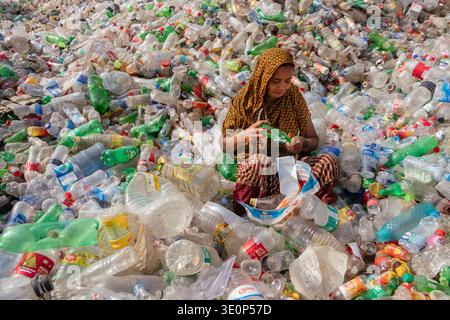 March 13, 2026, Dhaka, Dhaka, Bangladesh: A woman worker sorts used plastic bottles in a recycling factory in Dhaka, Bangladesh. She helps to prevent the bottles from being discarded, sent to landfill, where they can take 1,000 years to biodegrade, or incinerated, which produces toxic fumes. The emission of CO2 and other greenhouse gases will be reduced if recycling takes place in the production of new plastics. This small yet significant act supports environmental sustainability by promoting a responsible cycle of reuse, reducing the strain on natural resources, and safeguarding our ecosystem Stock Photo