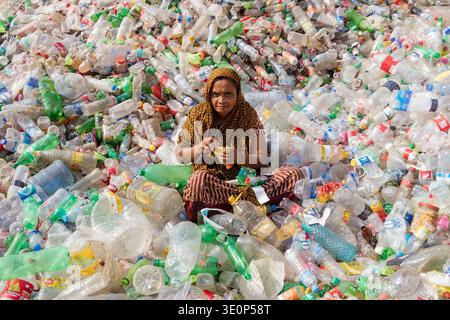 March 13, 2026, Dhaka, Dhaka, Bangladesh: A woman worker sorts used plastic bottles in a recycling factory in Dhaka, Bangladesh. She helps to prevent the bottles from being discarded, sent to landfill, where they can take 1,000 years to biodegrade, or incinerated, which produces toxic fumes. The emission of CO2 and other greenhouse gases will be reduced if recycling takes place in the production of new plastics. This small yet significant act supports environmental sustainability by promoting a responsible cycle of reuse, reducing the strain on natural resources, and safeguarding our ecosystem Stock Photo