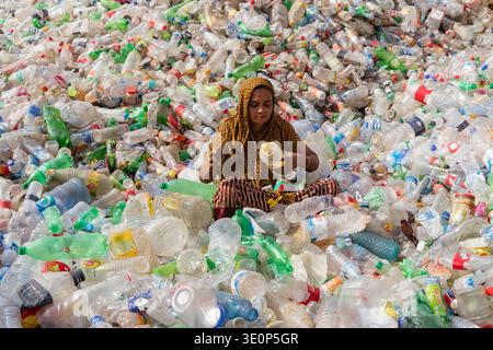 March 13, 2026, Dhaka, Dhaka, Bangladesh: A woman worker sorts used plastic bottles in a recycling factory in Dhaka, Bangladesh. She helps to prevent the bottles from being discarded, sent to landfill, where they can take 1,000 years to biodegrade, or incinerated, which produces toxic fumes. The emission of CO2 and other greenhouse gases will be reduced if recycling takes place in the production of new plastics. This small yet significant act supports environmental sustainability by promoting a responsible cycle of reuse, reducing the strain on natural resources, and safeguarding our ecosystem Stock Photo