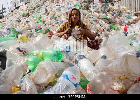 March 13, 2026, Dhaka, Dhaka, Bangladesh: A woman worker sorts used plastic bottles in a recycling factory in Dhaka, Bangladesh. She helps to prevent the bottles from being discarded, sent to landfill, where they can take 1,000 years to biodegrade, or incinerated, which produces toxic fumes. The emission of CO2 and other greenhouse gases will be reduced if recycling takes place in the production of new plastics. This small yet significant act supports environmental sustainability by promoting a responsible cycle of reuse, reducing the strain on natural resources, and safeguarding our ecosystem Stock Photo