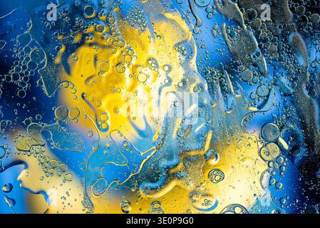 Creative macro photography of colorful oil and water mix featuring vibrant bubbles, organic fluid shapes and dynamic artistic composition. Stock Photo