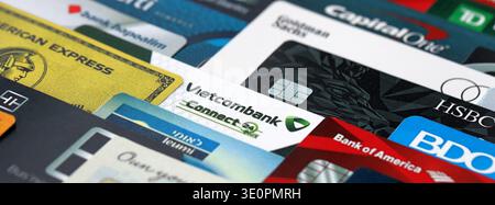 KYIV, UKRAINE - JANUARY 28, 2026 Big pile of credit cards with logos of various banks of whole world. Concept of credit or debit cards usage. Banking, Stock Photo
