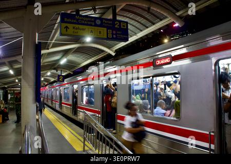 Jakarta, Indonesia – Nov 2025: A packed Cikarang-bound commuter train fills the platform during evening rush, with standing passengers crowding. Stock Photo