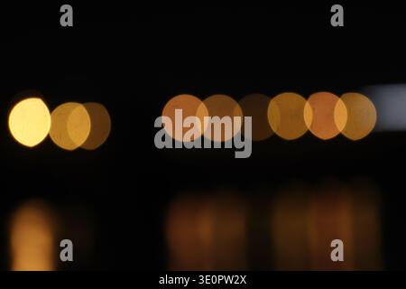 A blurred city street image at night. Abstract blur urban city street road with lighting bokeh for background. Stock Photo