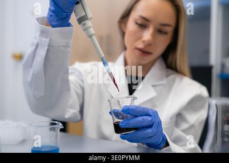 Performing accurate liquid transfer using a micropipette for sample preparation in a clinical research environment. Stock Photo