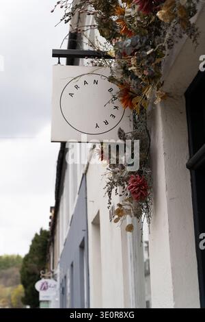Aran Bakery sign decorated with dried flowers on a white-walled building in Dunkeld, Scotland Stock Photo