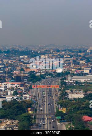 Aerial view shows a bustling urban area. Buildings line roads, with ...