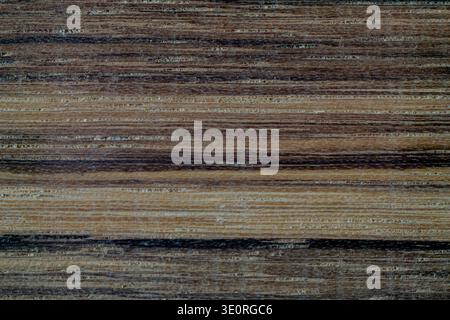 Macro close up of ovangkol hardwood plank showing rich natural grain pattern. Smooth planed timber surface, untreated and unfinished exotic hardwood Stock Photo