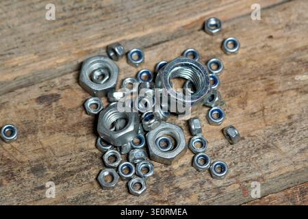 'Oh nuts' concept using nuts hardware spilled on a rustic wood work bench Stock Photo