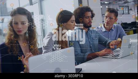Working business-casual team leaning and typing on laptops in open plan office, with UI overlays Stock Photo