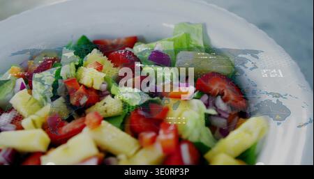 Showing white bowl holding lettuce, tomatoes, cucumber, yellow cubes on table, tech map overlay Stock Photo