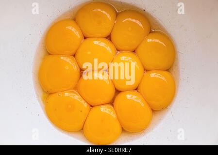 Egg yolks separated in a white mixing bowl Stock Photo