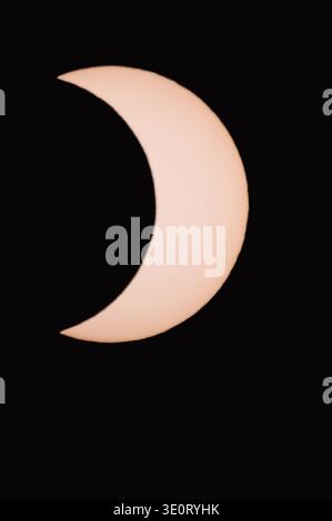 Partial solar eclipse in the dark. Actual image taken through a solar filter. Stock Photo