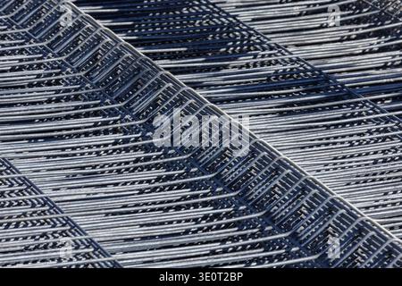 Reinforcement steel mesh stack industrial background. Close perspective of stacked reinforcement steel mesh creating repeating industrial pattern used Stock Photo