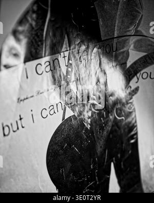A moody black-and-white photograph of a crumpled, torn music poster with visible typography and a silhouetted figure, showing worn texture, urban deca Stock Photo