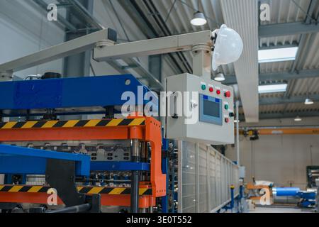 Automated production line inside a manufacturing plant shows various industrial machines and equipment working without any workers present. Stock Photo