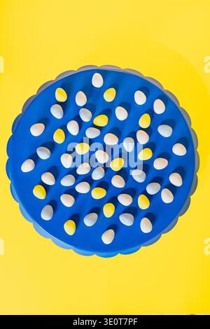 Minimalist food design with Easter eggs on blue tray and yellow background Stock Photo