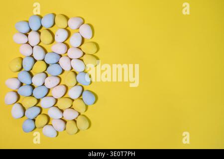 Pastel Easter eggs on yellow background with copy space Stock Photo