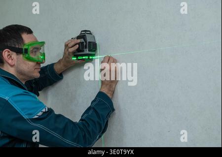 A man measures distance with a laser level.  Stock Photo