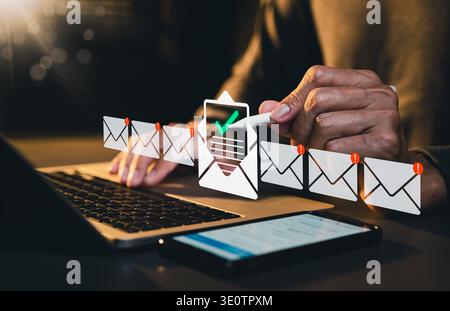Email verification concept. Person using laptop and checking incoming messages with inbox icons representing email management, notification control, Stock Photo